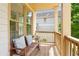 Cozy porch with wooden bench, pillows, and sunny window overlooking a street at 1858 Perry Nw Blvd, Atlanta, GA 30318