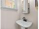 Cozy powder room features a pedestal sink with modern fixtures and bright lighting at 1858 Perry Nw Blvd, Atlanta, GA 30318