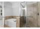 Bathroom featuring a walk-in shower, soaking tub and neutral tiling and a glass door at 901 Abernathy Ne Rd # 2050, Sandy Springs, GA 30328