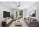 Bright living room with hardwood floors, sofa, and entertainment center; leads to an outdoor balcony at 901 Abernathy Ne Rd # 2050, Sandy Springs, GA 30328