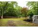 Spacious backyard featuring lush green grass, mature trees, and a wooden fence at 230 Milton Se Ave, Atlanta, GA 30315