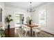 Bright dining room boasts hardwood floors, modern chandelier, and a view into the updated kitchen at 230 Milton Se Ave, Atlanta, GA 30315