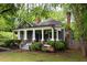 Charming home featuring a cozy front porch, beautiful landscaping, and mature trees at 230 Milton Se Ave, Atlanta, GA 30315