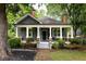 Charming home featuring a covered front porch with columns, brick accents, and mature landscaping at 230 Milton Se Ave, Atlanta, GA 30315