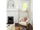 Close up of a fireplace, styled with a mirror, decor and adjacent comfy chair at 230 Milton Se Ave, Atlanta, GA 30315