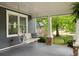 Inviting front porch showcases a swing, columns, and views of the lush front yard at 230 Milton Se Ave, Atlanta, GA 30315