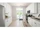 Stylish kitchen features white cabinetry, stainless appliances, granite countertops, and french doors to the deck at 230 Milton Se Ave, Atlanta, GA 30315