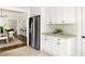 Open-concept kitchen with stainless steel refrigerator, white cabinets, and view into dining and living spaces at 230 Milton Se Ave, Atlanta, GA 30315