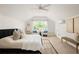 Bright main bedroom features vaulted ceilings, a ceiling fan, and a cozy seating area with a view of the yard at 230 Milton Se Ave, Atlanta, GA 30315