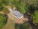 Aerial view of a one-story home with a new gray roof surrounded by green grass and trees at 2604 Flat Shoals Sw Rd, Conyers, GA 30094