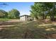 Expansive backyard featuring a large lawn and lush mature trees surrounding the property on a sunny day at 2604 Flat Shoals Sw Rd, Conyers, GA 30094