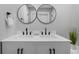Elegant bathroom featuring a dual sink vanity with modern fixtures and two mirrors above each sink at 2604 Flat Shoals Sw Rd, Conyers, GA 30094