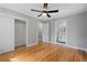 A spacious bedroom with a ceiling fan and light gray walls, plus closet and doorway to bathroom at 2604 Flat Shoals Sw Rd, Conyers, GA 30094
