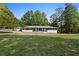 Well-maintained home with a large front yard, complemented by mature trees and landscaping at 2604 Flat Shoals Sw Rd, Conyers, GA 30094