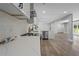 A bright, open kitchen featuring stainless steel appliances, a tile backsplash, and wood grain floors at 2604 Flat Shoals Sw Rd, Conyers, GA 30094