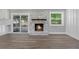 Cozy living room with a stone fireplace, wood mantel, and sliding doors to a screened patio at 2604 Flat Shoals Sw Rd, Conyers, GA 30094