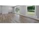 Living room with light wood floors, white trim, and large windows overlooking the yard at 2604 Flat Shoals Sw Rd, Conyers, GA 30094