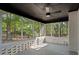 Relaxing screened porch featuring a ceiling fan, gray floors, white brick walls, and wooded views at 2604 Flat Shoals Sw Rd, Conyers, GA 30094