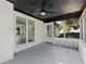 A screened porch with gray flooring, white brick and a ceiling fan, provides a relaxing outdoor space at 2604 Flat Shoals Sw Rd, Conyers, GA 30094