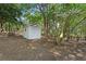 White storage shed in the yard, surrounded by trees, provides additional space for outdoor equipment and tools at 2604 Flat Shoals Sw Rd, Conyers, GA 30094
