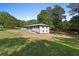 Exterior view of the house and detached garage on a spacious lot with a well-kept lawn at 2604 Flat Shoals Sw Rd, Conyers, GA 30094