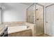 Bathroom featuring tub, shower, and neutral tile at 4679 Glenshire Pl, Atlanta, GA 30338