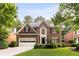 Charming brick home featuring a manicured lawn and attached garage in a lush, green neighborhood at 4679 Glenshire Pl, Atlanta, GA 30338