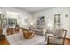 Bright living room featuring hardwood floors, neutral decor, and large windows with backyard views at 4679 Glenshire Pl, Atlanta, GA 30338