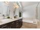Main bathroom with dual sinks, soaking tub, and modern fixtures at 4679 Glenshire Pl, Atlanta, GA 30338