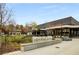 Street view of the Ashford Lane shopping area, showcasing stores and seating near lush green space at 4679 Glenshire Pl, Atlanta, GA 30338
