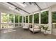 Relaxing sunroom with ceiling fan, floor-to-ceiling windows, and views of the trees at 4679 Glenshire Pl, Atlanta, GA 30338