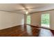Bright bedroom with hardwood floors, a ceiling fan, and natural light from two windows at 3539 Evans Mill Rd, Lithonia, GA 30038