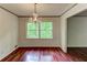 Well-lit dining room featuring a chandelier, natural light, and views of lush greenery through a double window at 3539 Evans Mill Rd, Lithonia, GA 30038