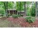 Charming brick two-story home with black shutters surrounded by lush greenery and mature trees at 3539 Evans Mill Rd, Lithonia, GA 30038