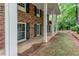 Detailed shot of brick facade with black shutters, showing the home's front door and side yard at 3539 Evans Mill Rd, Lithonia, GA 30038
