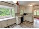 Eat-in kitchen with white cabinets, stainless steel sink, and view to adjacent room at 3539 Evans Mill Rd, Lithonia, GA 30038