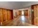 Spacious living room featuring wood paneling, hardwood floors, a ceiling fan, and access to the backyard at 3539 Evans Mill Rd, Lithonia, GA 30038