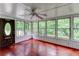 Bright sunroom with hardwood floors, a ceiling fan, and large windows that offer beautiful views of the outdoors at 3539 Evans Mill Rd, Lithonia, GA 30038