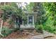 View of the sunroom exterior, screened in, attached to a brick home, and surrounded by foliage at 3539 Evans Mill Rd, Lithonia, GA 30038