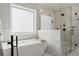 This modern bathroom features a freestanding tub and glass-enclosed shower with sleek fixtures at 4388 Cades Pointe, Marietta, GA 30066