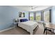 Bedroom with blue walls, ceiling fan, and windows showcasing a backyard view and a bench beneath at 4388 Cades Pointe, Marietta, GA 30066