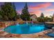 Inviting pool with rock waterfall feature surrounded by lush landscaping in a private backyard at sunset at 4388 Cades Pointe, Marietta, GA 30066