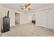 This bedroom features neutral walls and carpet with a ceiling fan, closet and a dresser at 502 Fortune Ridge Rd, Stone Mountain, GA 30087