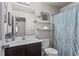 Bathroom with dark wood vanity, single sink, toilet, and a blue patterned shower curtain at 47 Gloster Mill Way, Lawrenceville, GA 30044