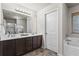 Well-lit bathroom features a double sink vanity with dark cabinets and separate tub at 47 Gloster Mill Way, Lawrenceville, GA 30044