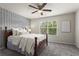 Bedroom featuring a ceiling fan, accent wall, and large window providing natural light at 47 Gloster Mill Way, Lawrenceville, GA 30044