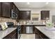 A well-equipped kitchen features stainless steel appliances, granite countertops, and dark wood cabinetry at 47 Gloster Mill Way, Lawrenceville, GA 30044