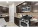 Modern kitchen features granite countertops, stainless steel oven range, and matching dark brown cabinetry at 47 Gloster Mill Way, Lawrenceville, GA 30044