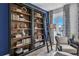 Library with a large bookcase, rolling ladder, and a comfortable chair by the window at 508 Regency Trl, Acworth, GA 30102