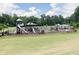 Community playground featuring slides, swings, and climbing structures surrounded by mature trees and a large green lawn at 508 Regency Trl, Acworth, GA 30102